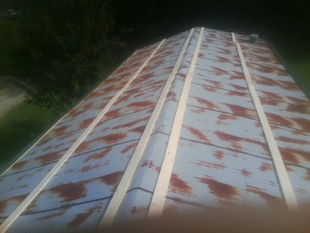 Rusted metal roof panels with new wood purlins before replacement — Storm Damage Roof Repair in New Washington by Roofing Brothers