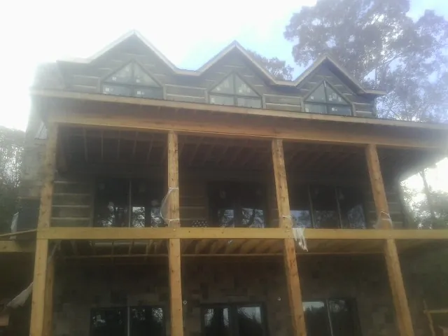 Dormers and porch framing on a large log home under construction — Roof Coating work by our crew in New Washington
